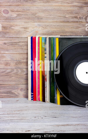 Retro styled image of a collection of old vinyl record lp's with sleeves on a wooden background. Copy space. Stock Photo