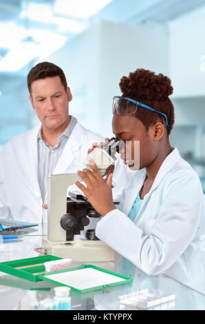 Two scientists, senior European male and young Afridan-American female, working in laboratory with a microscope. Focus on the face of the woman. Stock Photo