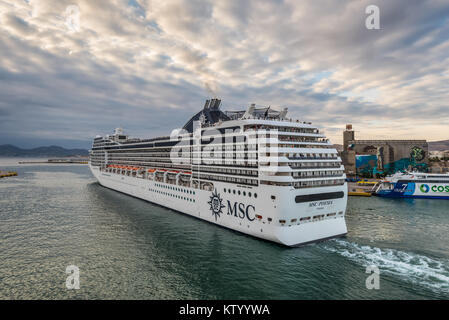 Piraeus, Greece - November 1, 2017: Cruise Ship MSC Poesia leaves from the largest Greek seaport of Piraeus in the evening in cloudy weather in Greece Stock Photo
