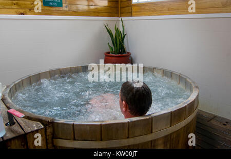 Man sitting in a bubbling hot tub Stock Photo