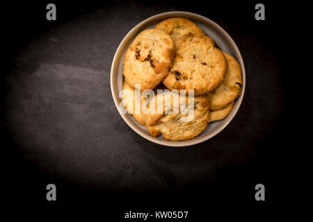 Delicious, yummy and luxurious home baked pistachio nut and chocolate chip shortbread cookies in a round bowl shot from above Stock Photo