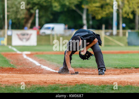 ZAGREB, CROATIA - SEPTEMBER 09, 2017: Baseball match between Baseball Club Zagreb and BK Olimpija 83. Plate umpire is cleaning home base Stock Photo