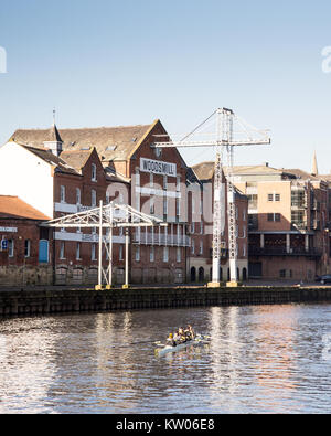 York, England, UK - January 29, 2017: A rowing team train on the River Ouse in front of the former Woodsmill warehouses on Queen's Staith docks in the Stock Photo