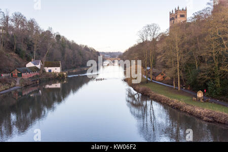 Durham, England, UK - January 29, 2017: University rowing crews train on the River Wear below the west face and towers of Durham Cathedral in the stee Stock Photo