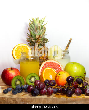 Juices smoothies and fresh pineapple and orange drinks with summer fruits Stock Photo