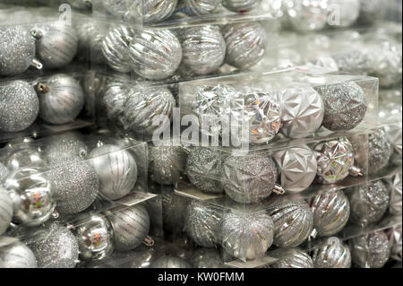 Christmas balls are silvery, on the supermarket shelf. Toys for sale Stock Photo
