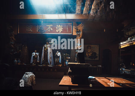 Interior On Lang temple with spirit staue, incense burning and smoke. Unidentified people visit, praying for lucky and happy in first day of month Stock Photo