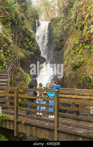 Ess-na-larach waterfall in Glenariff Forest Park with a family looking at it from a wooden bridge Stock Photo