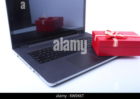 Laptop and christmas gifts box on white desk Stock Photo