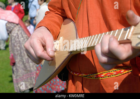 Balalaika in hands of the man dressed in a national Russian suit, close up Stock Photo