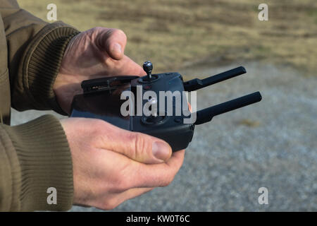 Hands holding controller for drone that uses a cell phone in the winter - selective focus Stock Photo