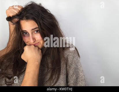 Domestic violence towards women concept with a close up view of the fists of a man hitting a woman with a black bruised eye Stock Photo