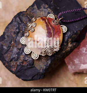 Stone bead necklace pendant on natural background Stock Photo