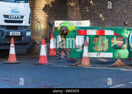 Construction worker using an angle grinder on the road, Ashford, Kent Stock Photo