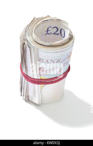 A roll of British notes held together by an elastic band on a white background. Stock Photo