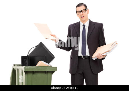 Angry businessman throwing his stuff in a trash can isolated on white background Stock Photo