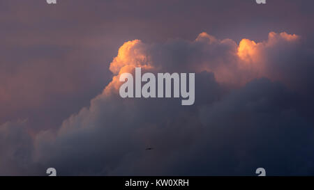clouds catching the sun and a bird Stock Photo