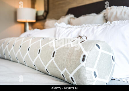 Closeup of new bed comforter with decorative pillows in bedroom in staging model home apartment or house Stock Photo