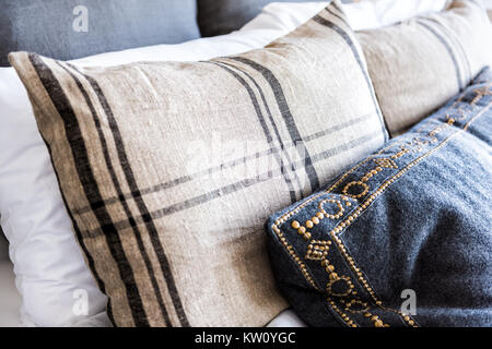 Closeup of new bed comforter with many decorative pillows in bedroom in staging model home, house or apartment Stock Photo