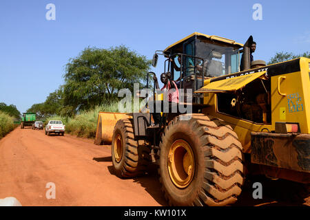 ETHIOPIA, Gambela, Abobo, the government give large land for cheap lease to domestic and foreign investors, after deforestation the investors cultivate large farm lands with food crop for export, local people are often settled under villagization programs, John Deere combine harvester of Saudi Star Agricultural Development PLC is shifted on narrow road for the rice harvest , Saudi Star owned by Saudi-Ethiopian billionaire Sheikh Mohamed al-Amoudi has a rice farm of about 10.000 hectares along the Alwero river / AETHIOPIEN, Gambela, Abobo, die aethiopische Regierung verpachtet grosse Landflaech Stock Photo