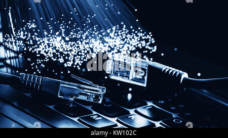 network cable closeup with fiber optical background, color fiber optical background with notebookk, Fiber optics lights abstract background Stock Photo
