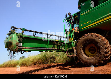 ETHIOPIA, Gambela, Abobo, the government give large land for cheap lease to domestic and foreign investors, after deforestation the investors cultivate large farm lands with food crop for export, local people are often settled under villagization programs, John Deere combine harvester of Saudi Star Agricultural Development PLC is shifted on narrow road for the rice harvest , Saudi Star owned by Saudi-Ethiopian billionaire Sheikh Mohamed al-Amoudi has a rice farm of about 10.000 hectares along the Alwero river / AETHIOPIEN, Gambela, Abobo, die aethiopische Regierung verpachtet grosse Landflaech Stock Photo