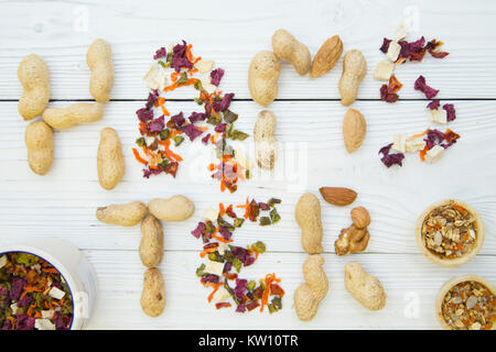 Pet care, veterinary concept. Hamster inscription made of rodent and rabbit food, dry vegetables, peanuts, grains and seeds on a white wooden table. Stock Photo