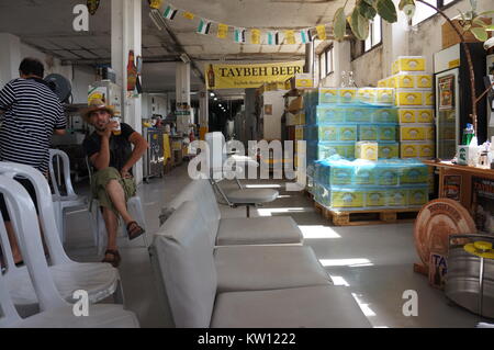 A tourist is drinking a beer in Taybeh Brewing Company in Palestine. Stock Photo