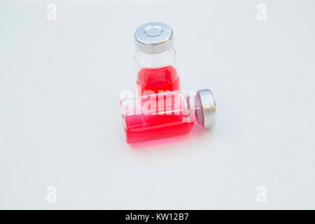 Veterinary and animal healthcare concept. Curing pets. Two glass ampouls with red liquid on a white background, close up. Space for your text or image Stock Photo