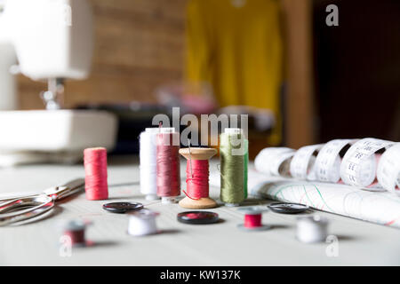 sewing, sewing on the sewing machine, sewing supplies, colored sewing threads, centimeter, tailors scissors, buttons Stock Photo