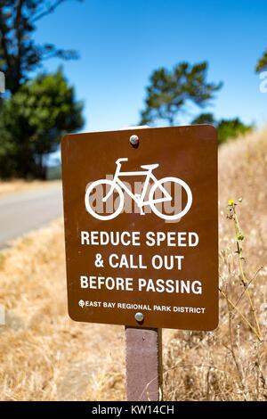 Sign warning cyclists to reduce their speed and call out while passing pedestrians on the Nimitz Way trail in Tilden Regional Park, Berkeley, California, July, 2016. Stock Photo