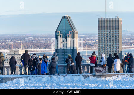 Montreal, CA - 26 December 2017: Tourists looking at Montreal Skyline from Kondiaronk belvedere in winter. Stock Photo