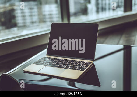 Silver laptop on glance table. Stock Photo