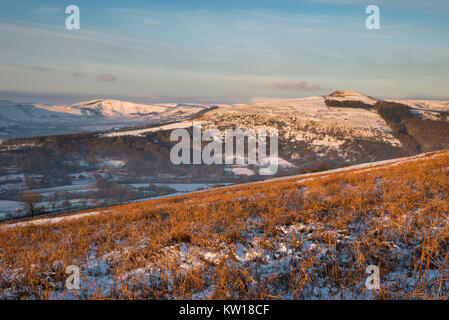 Beautiful winter morning at Bamford Edge in the Peak District, Derbyshire, England. View to Win Hil. Orange bracken in the snowy foreground. Stock Photo