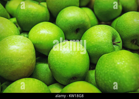 Ripe selected granny smith apples in rows at a grocery shop for sale. Green background of granny smith apples. Horizontal. Top view. Stock Photo