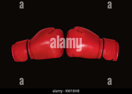 Red Boxing gloves isolated on black background. Two Boxing gloves to each other. Stock Photo