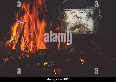 The kettle on the bonfire at camping in nature at night Stock Photo