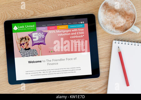 The Leek United Building Society website on an iPad tablet, resting on a wooden table beside a notepad, pencil and cup of coffee (Editorial only). Stock Photo