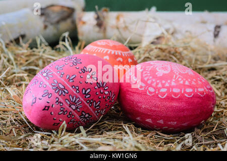 Easter Eggs in Red and Orange on Hay Stock Photo