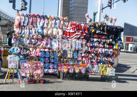 heavily loaded rack wondrous cheery bright colored kids Christmas toys & gifts many covered in clear plastic displayed for sale at Pemex gas station Stock Photo