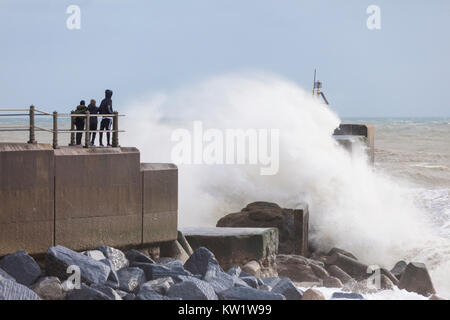 Hastings, East Sussex, UK. 29th Dec, 2017. Gale force winds in the seaside town of Hastings this morning, with gusts of wind reaching 46 mph. People watch nearby getting sea sprayed as crashing waves batter the harbour arm. Photo Credit: Paul Lawrenson/Alamy Live News Stock Photo