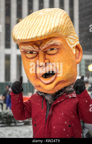 New York, USA, 30 Dec 2017.  A man wearing a mask mocking a chained US President Donald Trump gives the thumbs up after a protest in midtown New York city.  Demonstrators braved a snowstorm to demand Trump's impeachment. Photo by Enrique Shore/Alamy Live News Stock Photo