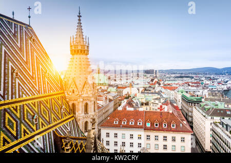 Aerial view over the historical rooftops of Vienna from the north tower of famous St. Stephen's Cathedral in beautiful golden evening light at sunset  Stock Photo