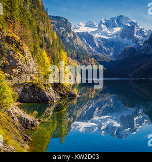 Beautiful view of idyllic colorful autumn scenery with Dachstein mountain summit reflecting in crystal clear Gosausee mountain lake in fall, Austria Stock Photo