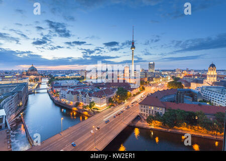 Classic aerial view of Berlin skyline with famous TV tower and Spree river in beautiful post sunset twilight during blue hour at dusk with dramatic cl