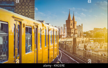 Berliner U-Bahn with famous Oberbaum Bridge in the background in beautiful golden evening light at sunset, Berlin Friedrichshain-Kreuzberg, Germany Stock Photo