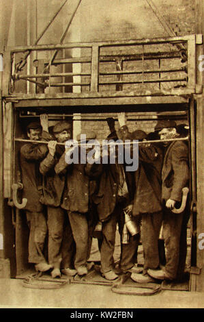 COAL MINING IN BRITAIN IN 1933 -  Lancashire coal miners descending to the coalface in a pit lift Stock Photo