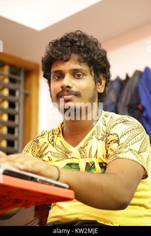 Chennai, India - May 20, 2016: Young man using laptop Stock Photo