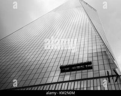 Window cleaners suspended on the side of a skyscraper cleaning the ...