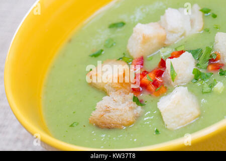 close up with green pea cream soup and bread crumbs Stock Photo